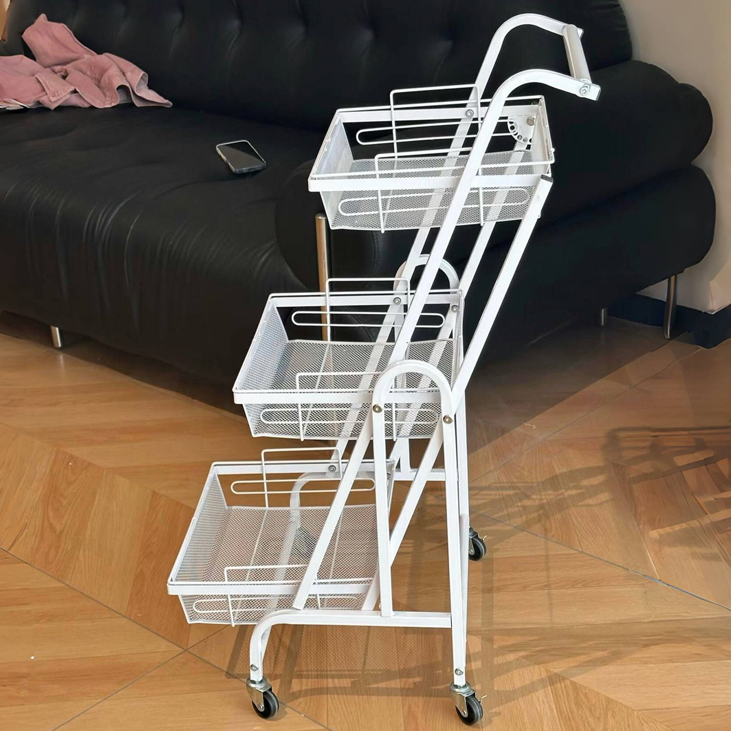 Kệ gấp gọn 3 tầng màu trắng có bánh xe, thiết kế hiện đại phù hợp với phòng khách.